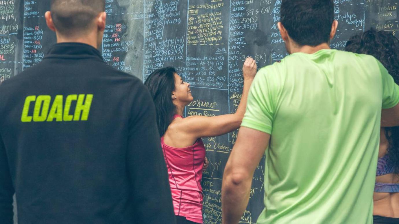 Woman writes on blackboard in coach's meeting