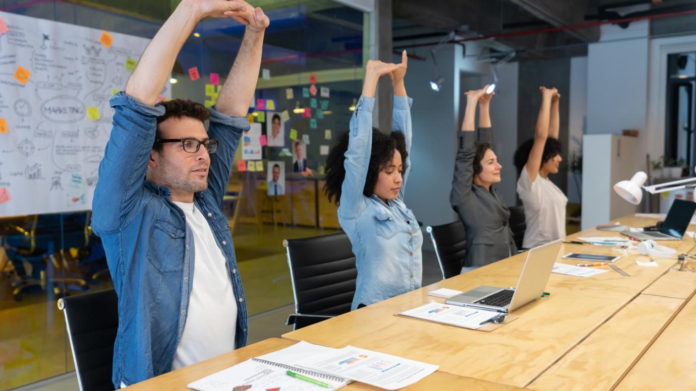 Group of workers doing stretching exercises in a business meeting at the office - healthy lifestyle concepts