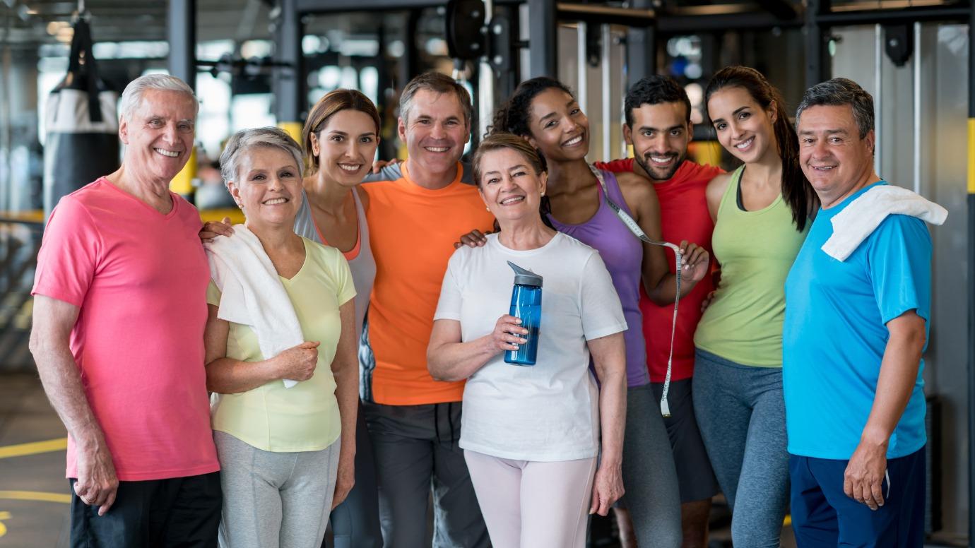 Happy group of people at the gym looking at the camera smiling