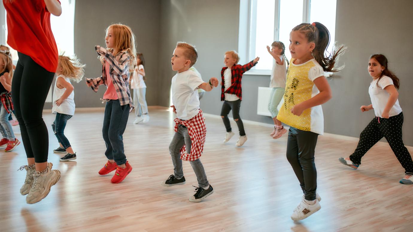 Group of little boys and girls dancing while having choreography class