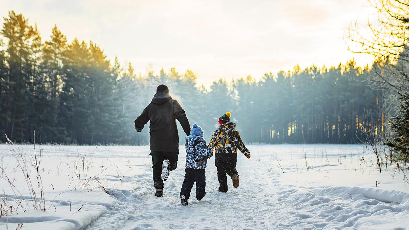 A father and two children in a winter forest