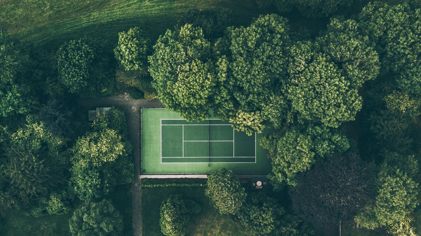 Aerial photo of tennis court surrounded by trees