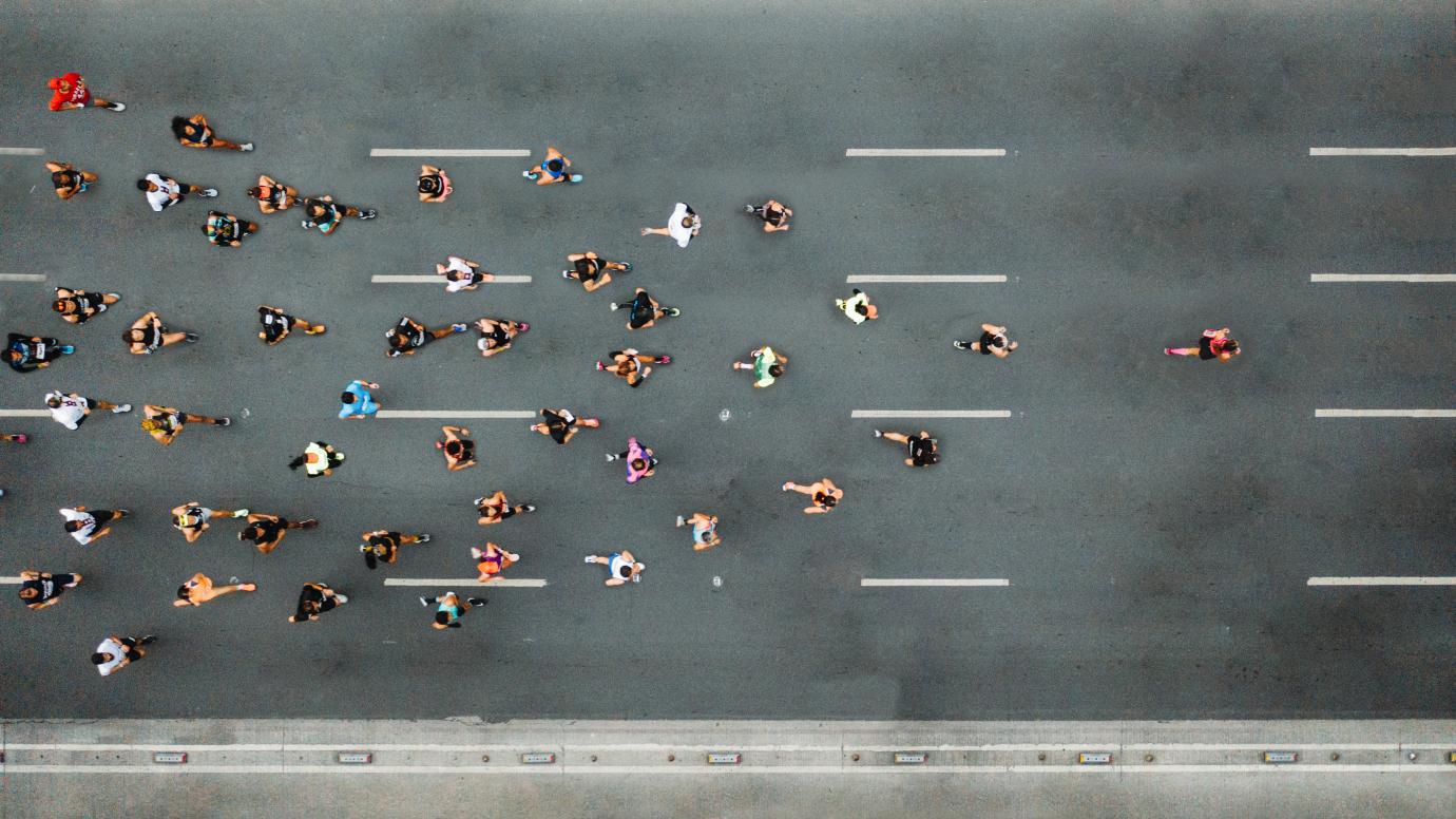 Aerial view of marathon city runners. One person leading marathon.
