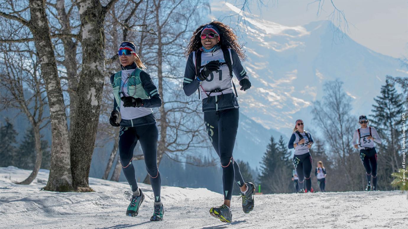 Two female runners during a race on the snow in winter