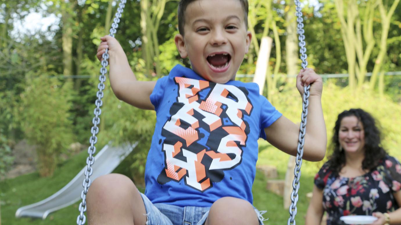 A smiling child on a swing